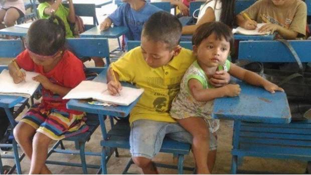 Con tal de no faltar a clases, llevó a su carnalito a la escuela.